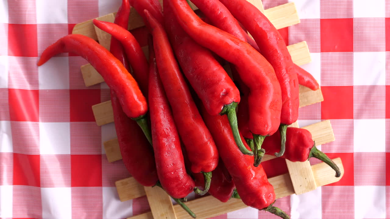 свежие красные перцы на деревянном подносе