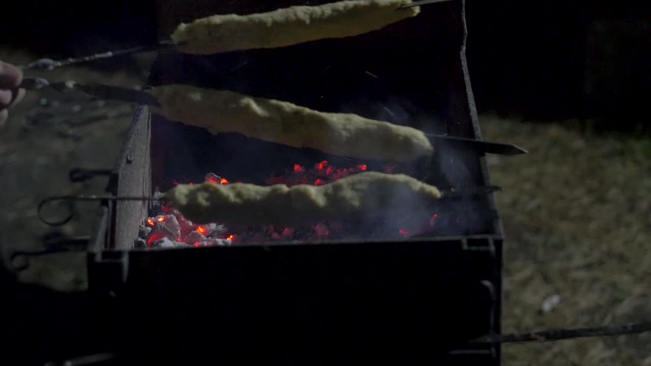 Cucinare Shish Kebab su griglia a carbone di notte