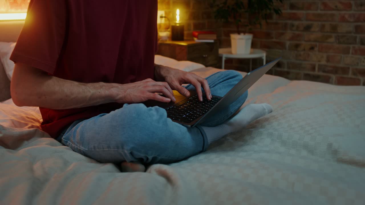 hombre trabajando en la computadora portátil en la cama por la noche