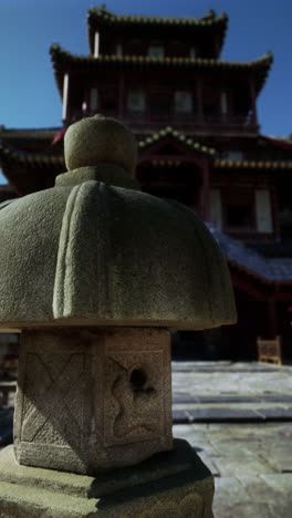 ancient stone lantern in front of a chinese temple