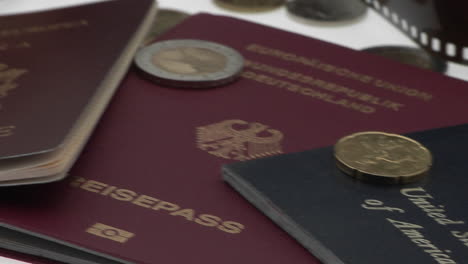 los pasaportes y las monedas se muestran en una superficie blanca