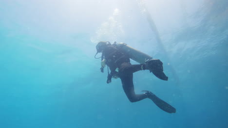 Cinematic-slow-motion-shot-of-a-scuba-diver-moving-gracefully-through-the-water-in-clear-waters,-120FPS,-4K,-Slomo