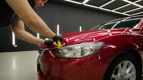 headlight polishing, processing of car lights. a car service worker polishes the headlight of a passenger car. professional polishing.