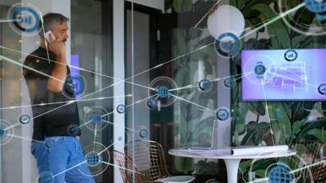 Animation of network of connections icons over caucasian businessman using smartphone