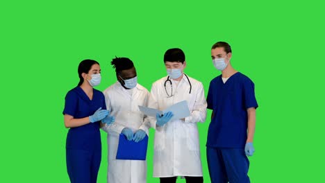grupo multirracial de jóvenes médicos discuten sobre documentos en una pantalla verde, clave de croma