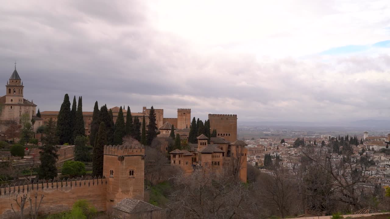 panorámica en cámara lenta sobre el palacio de la alhambra y la ciudad de granada en tiempo nublado