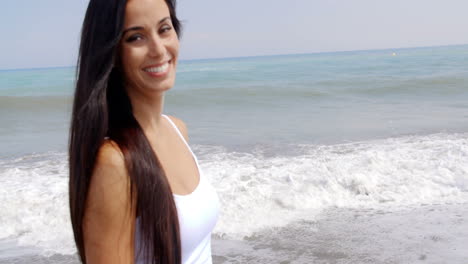 Mujer-Morena-En-La-Playa-Sonriendo-Sobre-El-Hombro