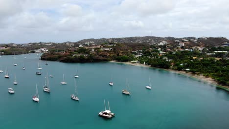 yachts moored in peaceful pickly bay marina, grenada, with lush hills in the background, aerial view