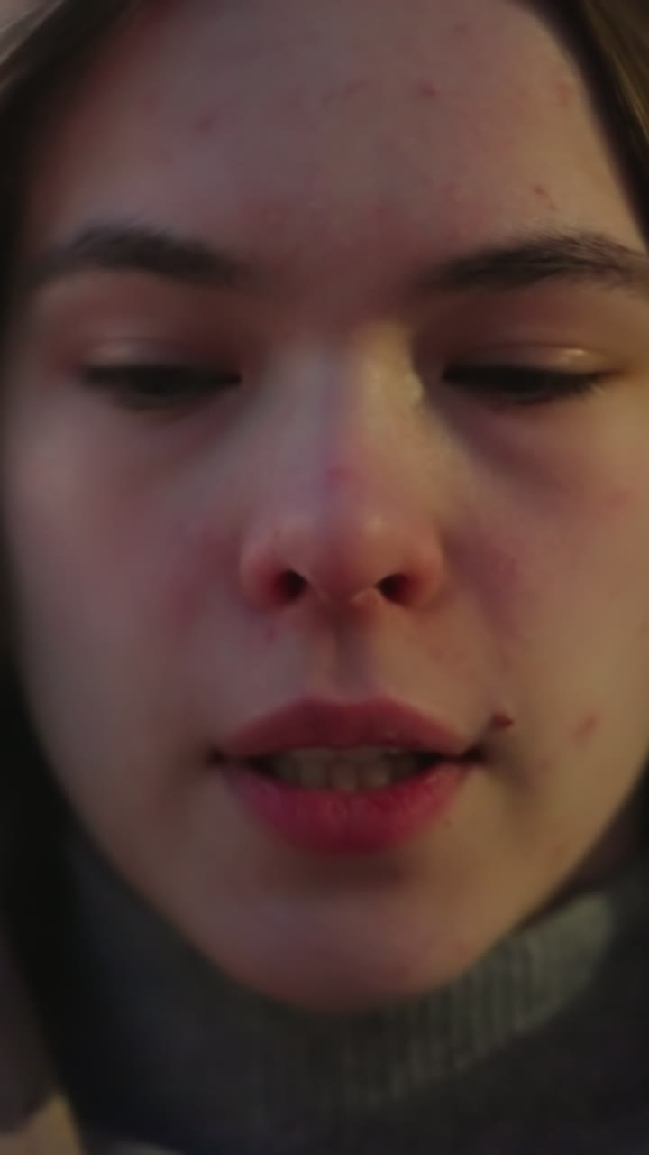 toma frontal de primer plano de la cara de una chica con un fondo borroso. el video destaca sus rasgos faciales con detalles nítidos contra un fondo de enfoque suave, capturando una atmósfera natural e íntima