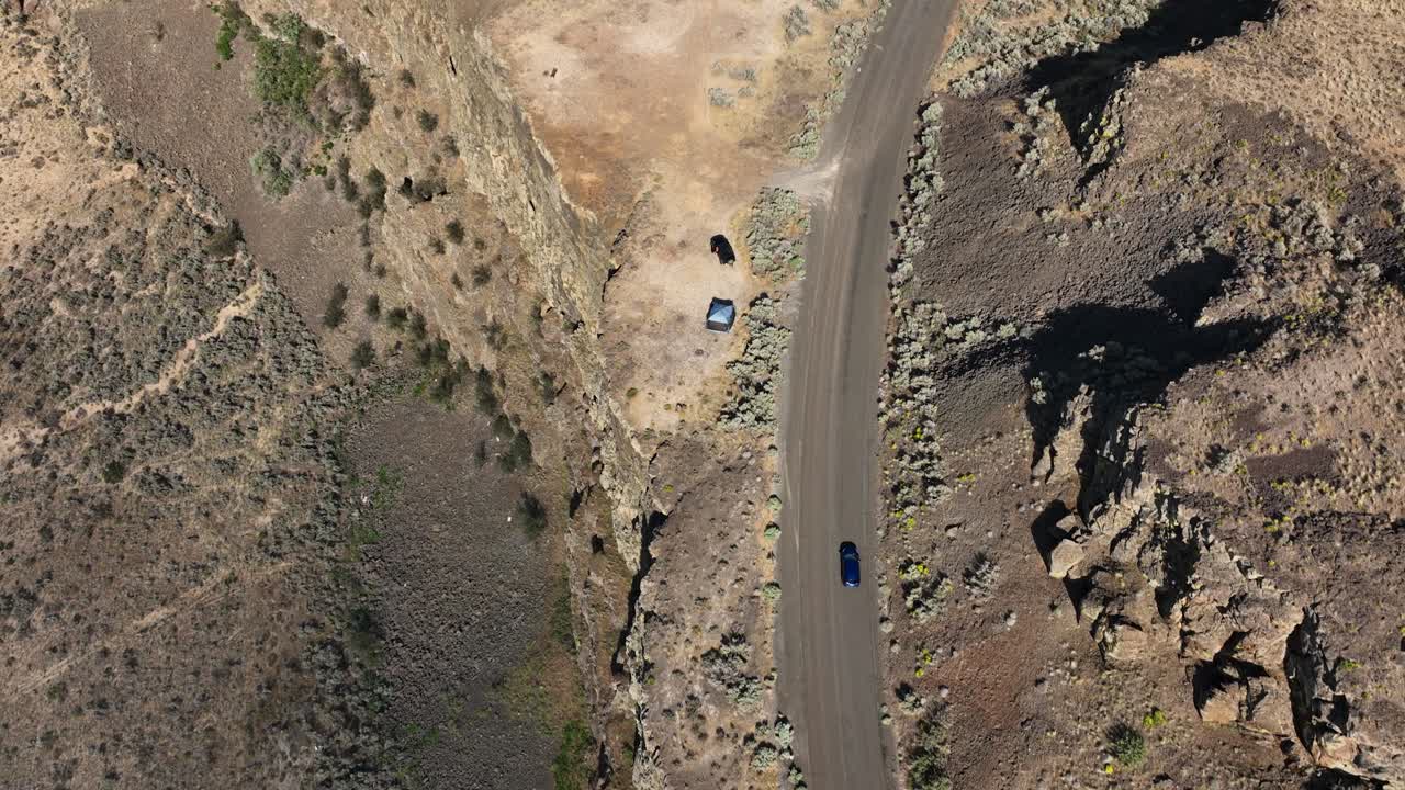 동부 워싱턴의 사막 지형을 주행하는 자동차의 하향식 공중 촬영