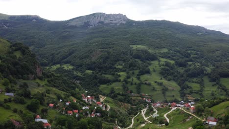 a serene, quaint neighborhood located in a lush, green valley with mountains in the background