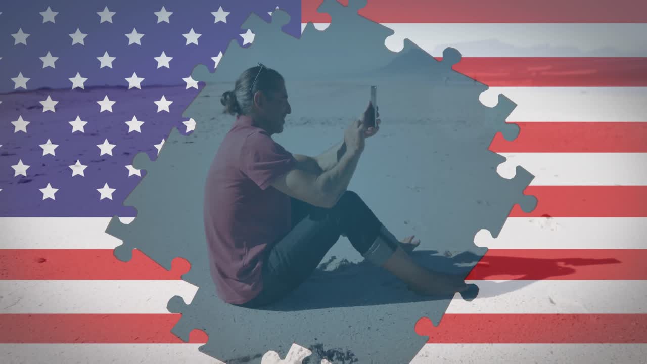 animación de rompecabezas de la bandera estadounidense que revela a un hombre usando un teléfono inteligente sentado en la playa