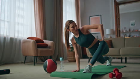 sport girl training home warming up legs muscles. serious woman morning workout