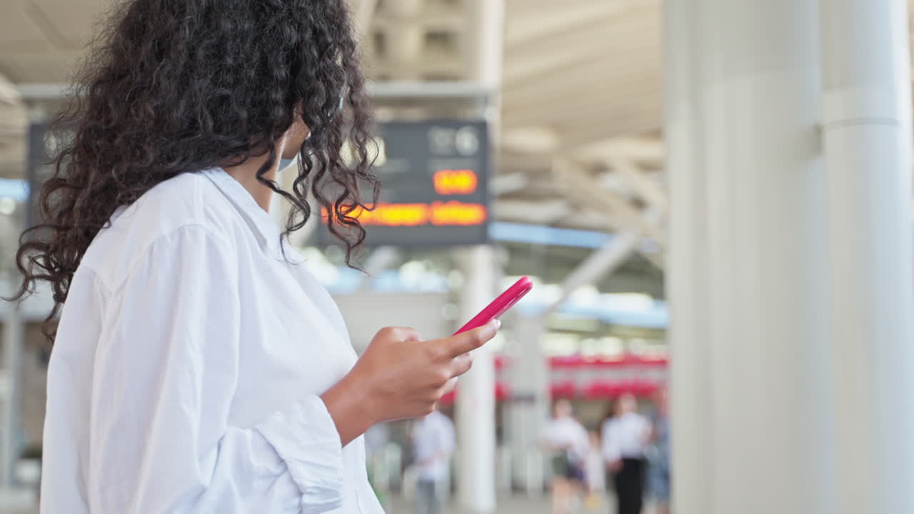 mujer en la estación de tren usando el teléfono