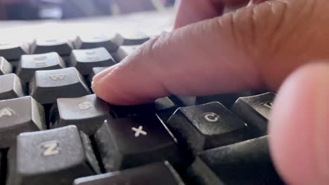 disparo de cerca de los dedos escribiendo en el teclado negro de la computadora