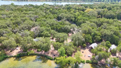 moviéndose hacia atrás y girando a la izquierda cerca de un pequeño campamento de cabañas en el borde de una ensenada del lago