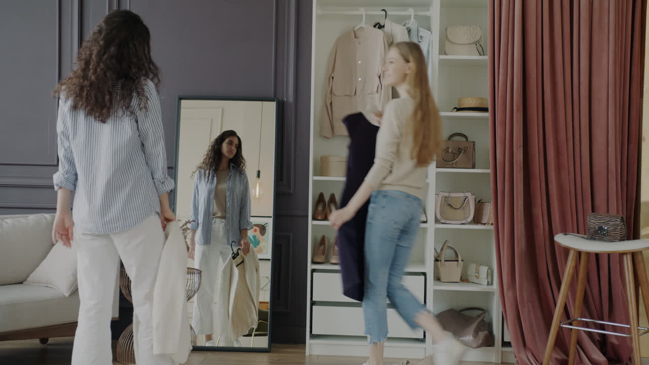 Two friends trying on clothes in a stylish wardrobe