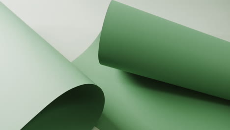 Close-up-of-green-rolled-piece-of-paper-on-white-background-with-copy-space-in-slow-motion