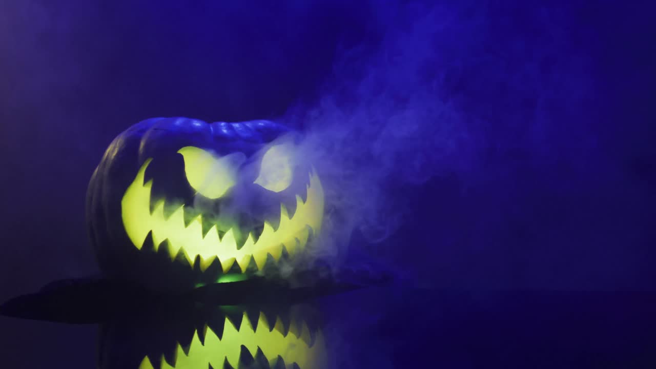 video de calabaza tallada de halloween con humo y luz azul sobre fondo negro
