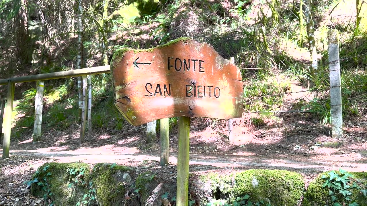A placa da fonte de São Bento fica junto a um caminho arborizado em San Pedro de Rocas, na Galiza, Espanha