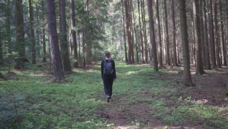 Junge-Frau-Mit-Rucksack-Geht-In-Den-Wald,-Um-In-Der-Natur-Energie-Zu-Tanken