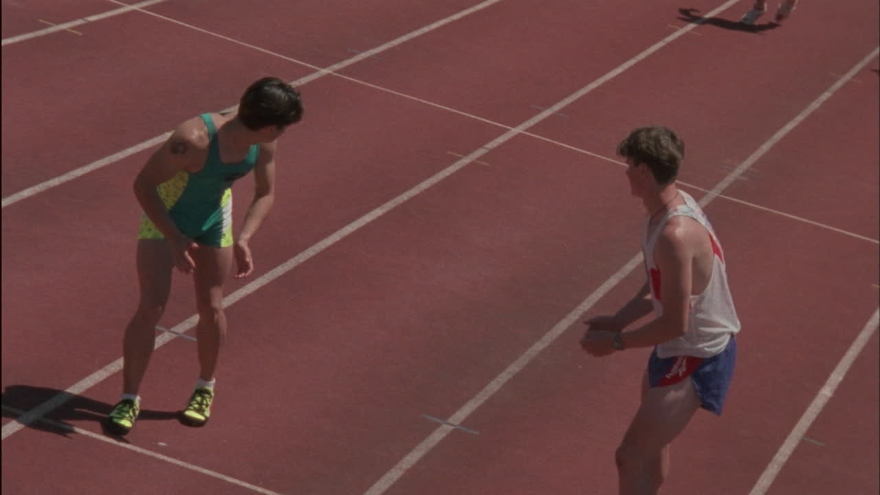 los corredores masculinos pasan la batuta en una carrera de relevos.