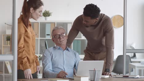 senior man complaining about work difficulties to young colleagues