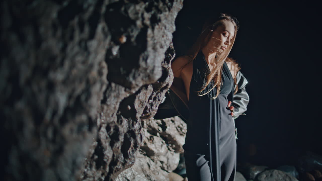 Fashion woman dancing night rocks beach closeup. Seductive model having party