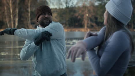 adult caucasian couple warming up before winter swimming.