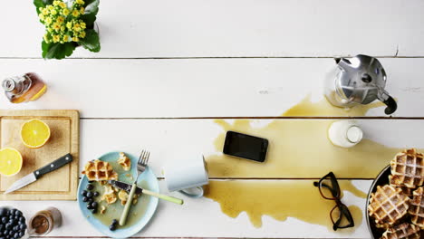 mesa de desayuno desordenada con derrame de café