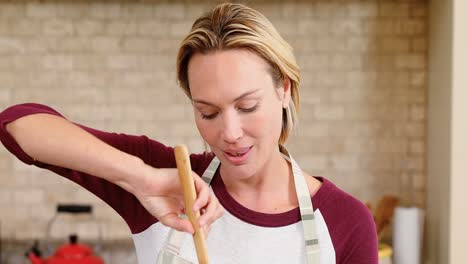 smiling young woman wearing apron mixing mixture in the kitchen 4k 4k