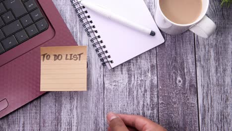 to do list on a desk with laptop, notebook, and coffee