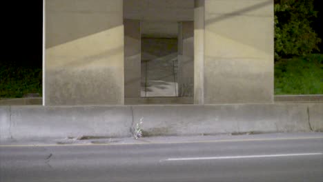 cars drive by in the late evening under an underpass in slow motion with a view from the side