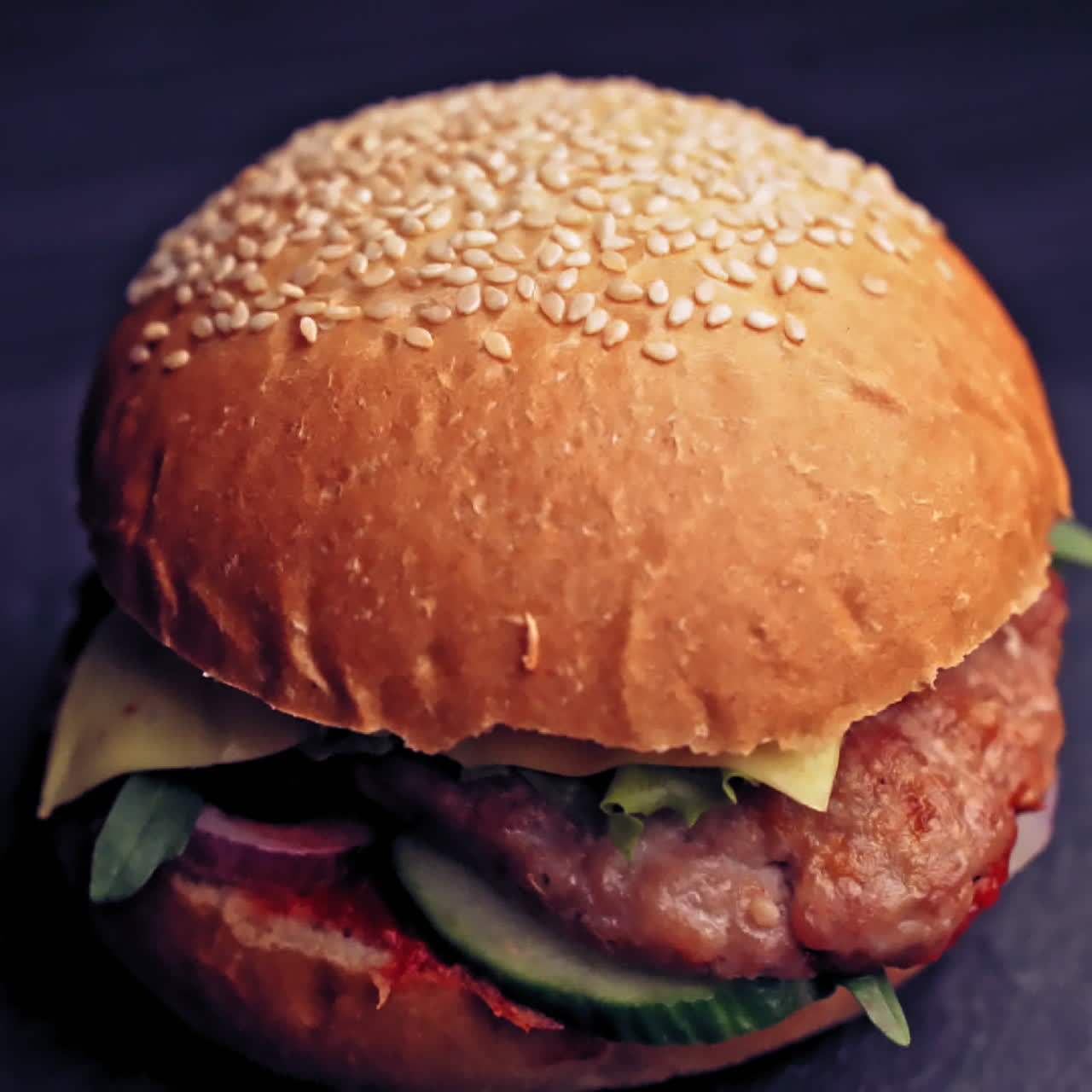 Fresh appetizing hamburger rotating on black background. Delicious grilled burgers