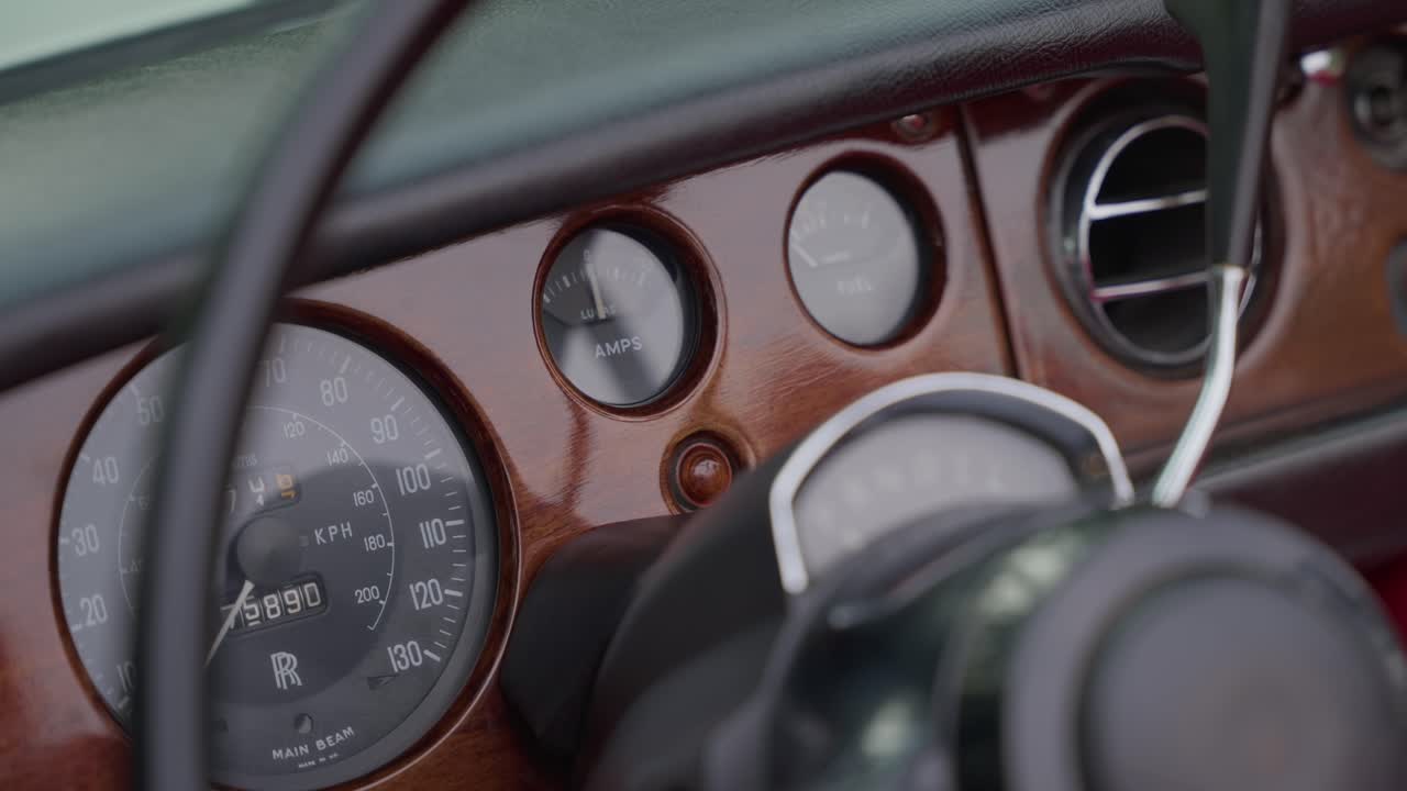 클로즈업 - 나무 패널 속도계와 복고풍 게이지가 있는 빈티지 자동차 대시보드