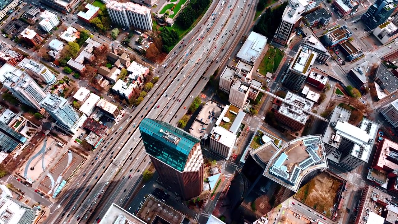Estradas movimentadas com vários carros atravessam o centro financeiro de Seattle, Washington, EUA. Vista aérea do panorama da metrópole durante o dia.