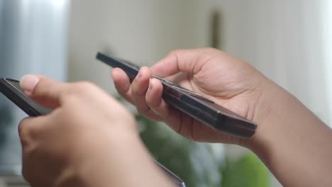 hands holding a smartphone and a tv remote control