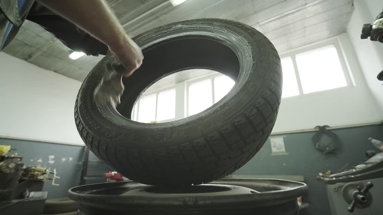 servicio de neumáticos. reparador de neumáticos en la estación de servicio. reemplazo de neumáticos de automóvil en disco de acero