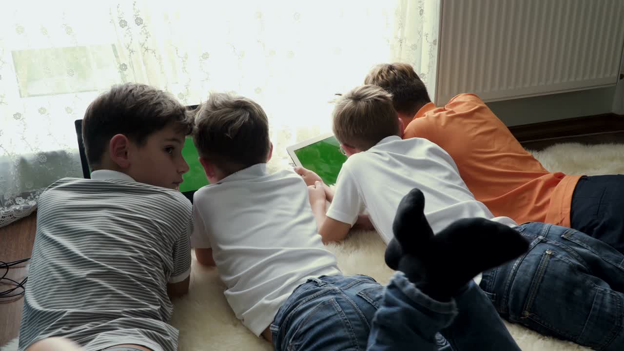 네 명의 작은 형제는 집에서 전자 기기를 사용합니다.