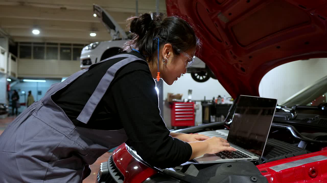 Female Mechanic Using Laptop for Car Diagnostics in Repair Shop