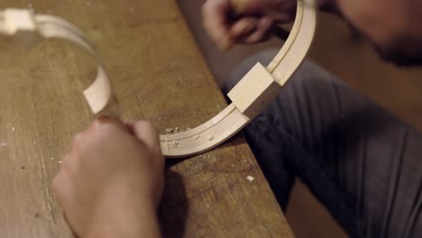 anonymous luthier creating violin ribs in workshop