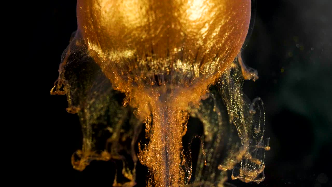 la pintura de brillo dorado fluye lentamente de la pelota