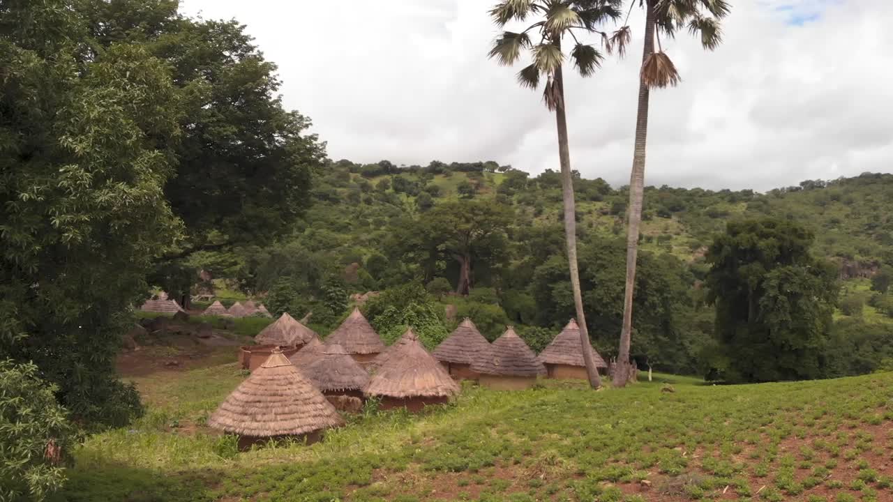vista aérea de pequeñas casas rústicas en un pueblo africano escondido, senegal, paisaje verde, nublado, disparo de drones