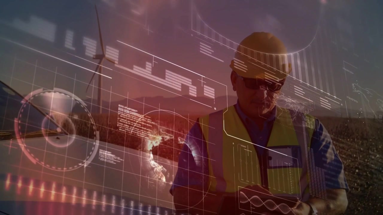 Male technician tapping device at wind farm, monitoring turbine as HUD graphs updating at dusk