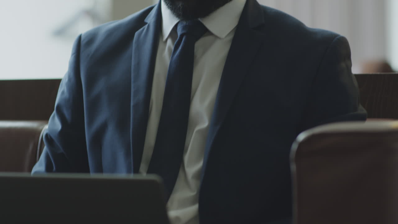 Black Businessman Working on Laptop in Hotel Lobby
