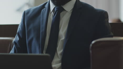 black businessman working on laptop in hotel lobby
