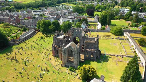 Melrose-Abbey-Ruins-a-Historic-Landmark,-Scottish-Borders-and-Small-Countryside-Town-Drone-Video