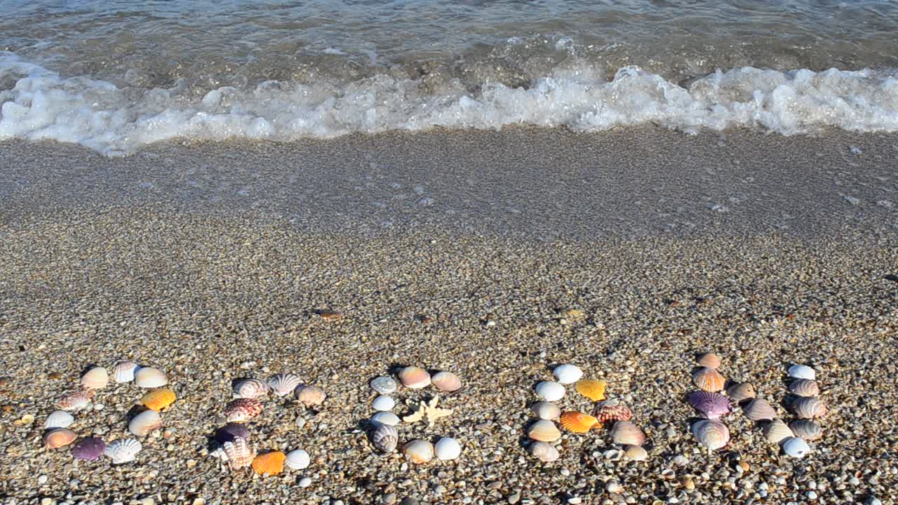Scritta 'oceano' sulla sabbia. Scatto sulla spiaggia.