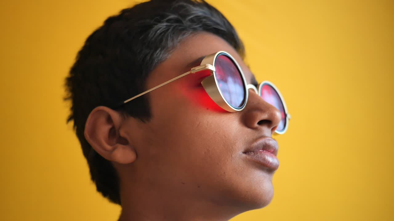 adolescente con gafas de sol rojas