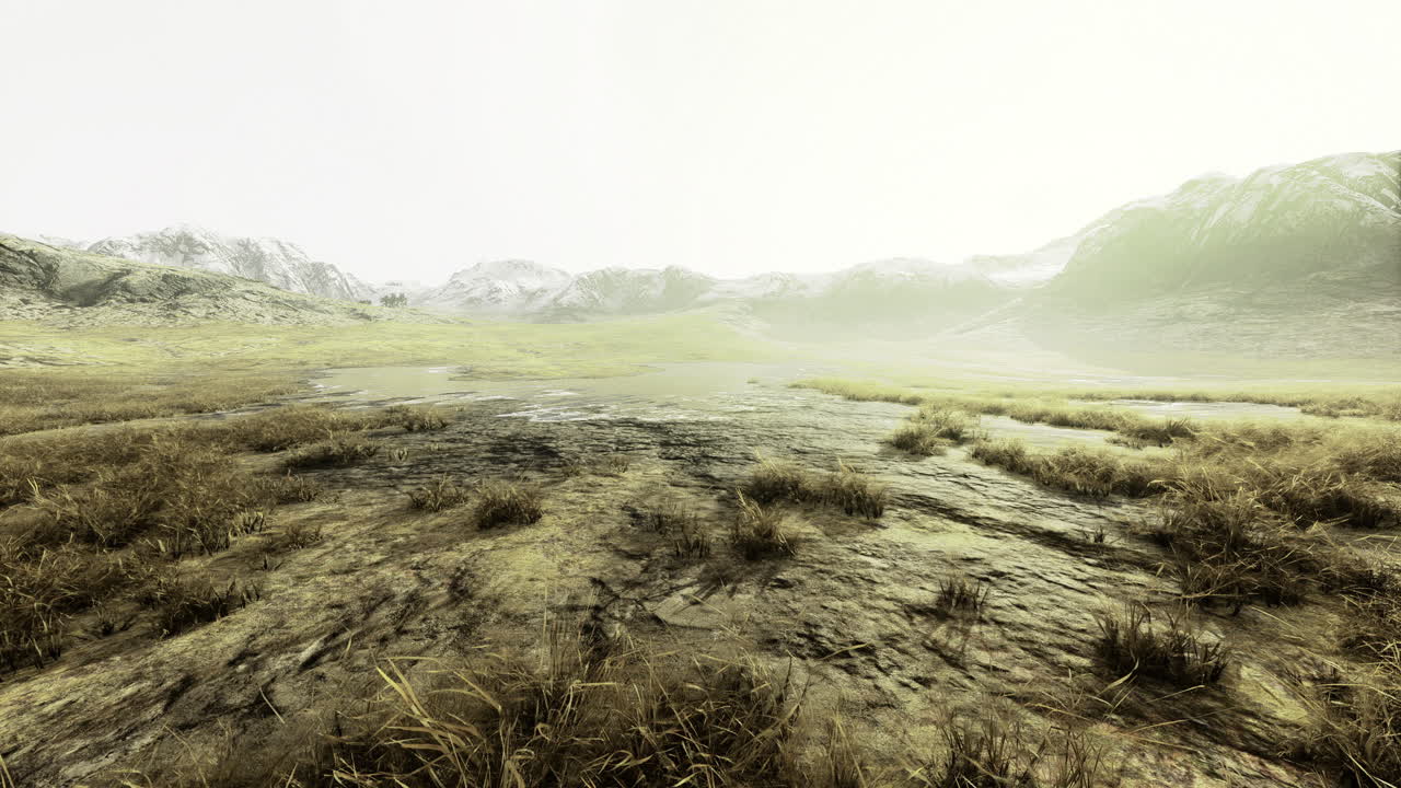 Vast landscape of rocky terrain and grassy plains in mist